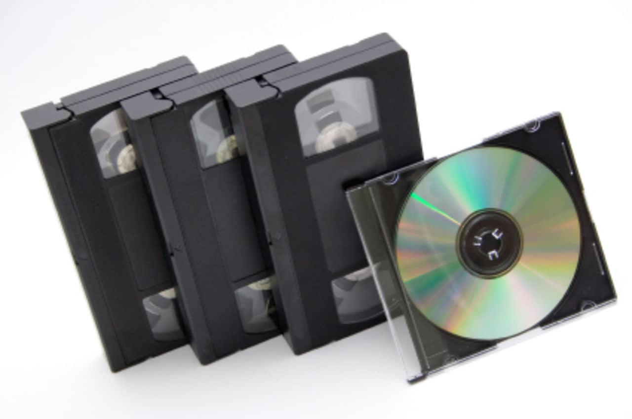 Three blank vhs tapes and one blank digital video disk in clear case.